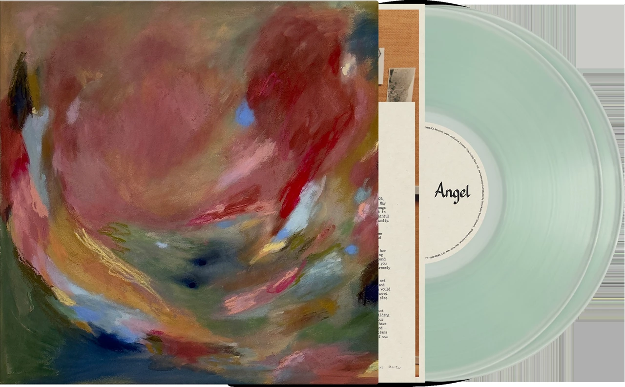 Image of Vinyl record album with an abstract painted cover in red, pink, blue, and green tones, shown next to a pale mint translucent record and inner sleeve labeled 'Angel'.