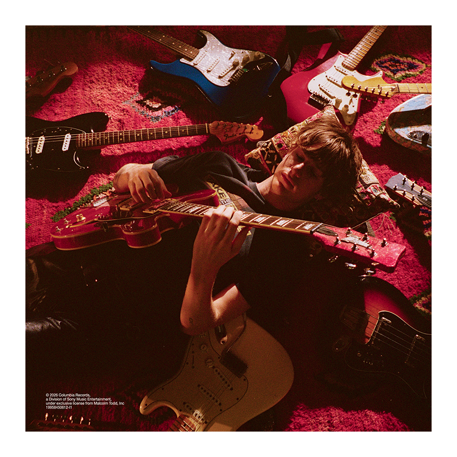 Image of Malcolm Todd – Do That Again standard CD insert featuring Malcolm lying on the floor surrounded by guitars while playing one